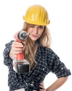 Frau zielt mit Bohrmaschine